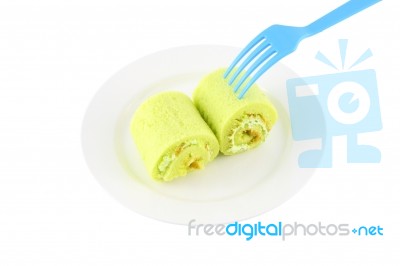 Green Sweet Roll Cake On Dish And Blue Fork Stock Photo