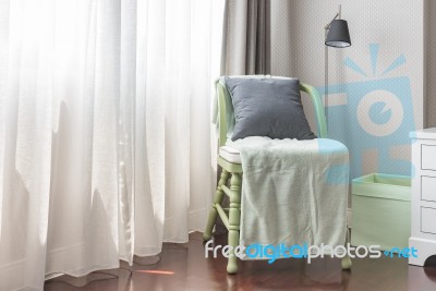 Green Wooden Chair With Grey Pillow And Green Blanket Stock Photo