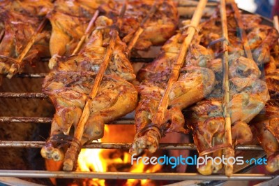 Grilled Chicken Thigh With Herb On The Flaming Grill Stock Photo