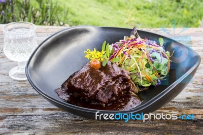 Grilled Rib Eye Beef Steak With Vegetable Salad In Black Bowl On Wood Table Stock Photo