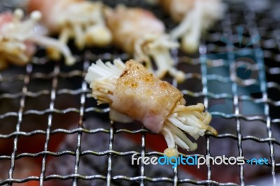 Grilling Bacon Wrapped With Needle Mushroom Stock Photo