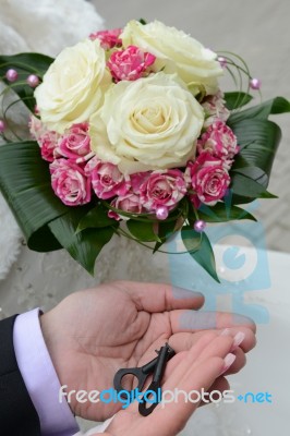 Groom Hands Hold The Keys And Hand The Bride With A Bouquet Of Bride Stock Photo