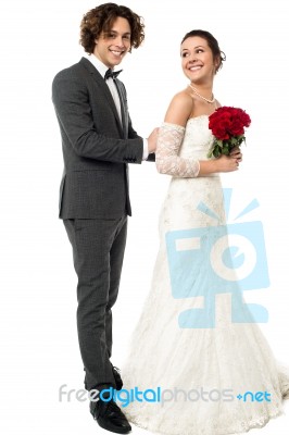 Groom Tucking Brides Dress Stock Photo