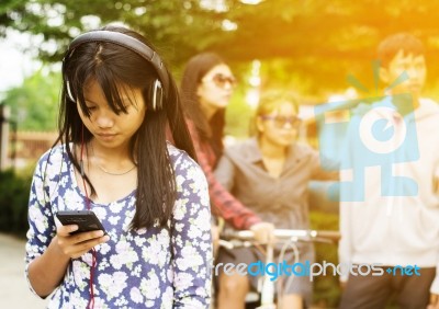 Group Of Asian Teenager Walking In The Park And Enjoyed Watching Video From Smartphone  Stock Photo