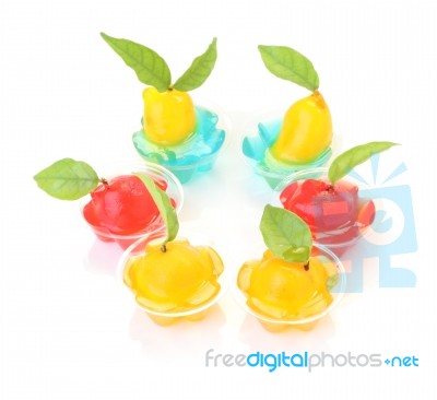 Group Of Deletable Imitation Fruits In Jelly Cup On White Floor Stock Photo