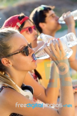 Group Of Friends Drinking Water In The Park Stock Photo