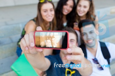 Group Of Friends Taking Photos With A Smartphone In The Street Stock Photo