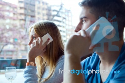 Group Of Friends Using Mobile Phone In Cafe Stock Photo