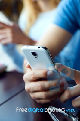 Group Of Friends Using Mobile Phone In Cafe Stock Photo