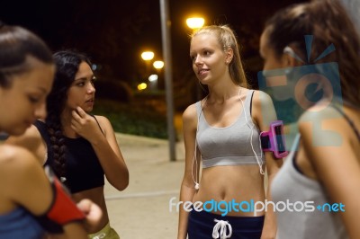 Group Of Girls Doing Stretching At Night Stock Photo