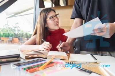 Group Of Hispanic Students Doing Homework Together In The School… Stock Photo