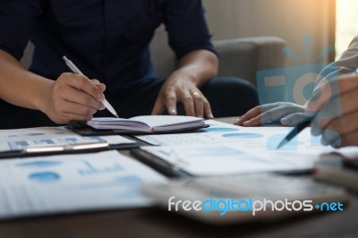 Group Of Successful Business People Discussing Paperwork And Usi… Stock Photo