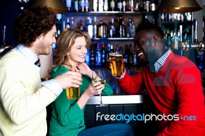 Group Of Three Friends In A Bar Drinking Beer Stock Photo