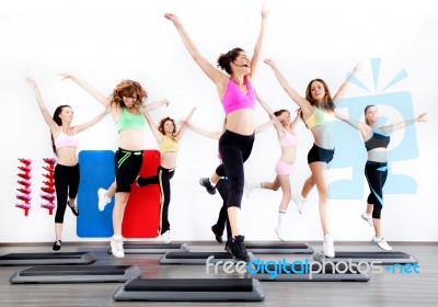 Group Of Women Doing Aerobics On Stepper Stock Photo