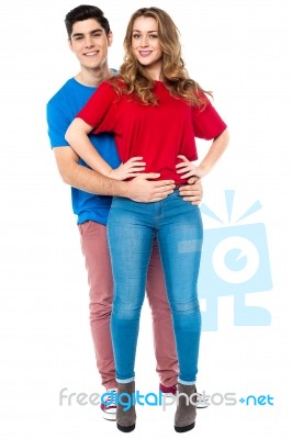 Guy Embracing His Girl From Behind, Arms Around Stock Photo