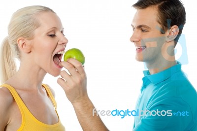 Guy Feeding Green Apple To Lover Stock Photo