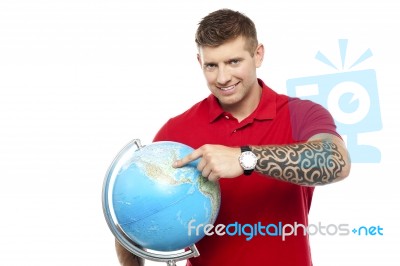 Guy Holding And Pointing Globe Stock Photo