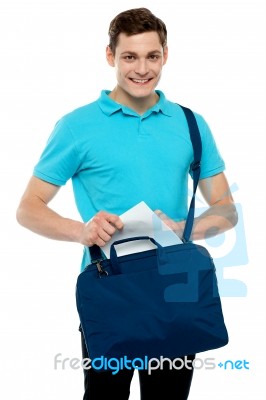 Guy Taking Out Paper From His Laptop Bag Stock Photo