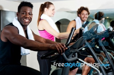 Gym Trainer Exercising Along With His Trainees Stock Photo