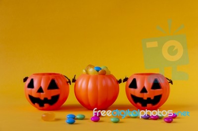 Halloween Jack O Lantern Bucket Filled With Candies On Yellow Background Stock Photo