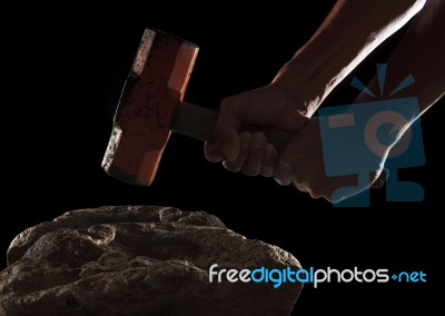 Hand And Hammer Breaking On The Rock Isolated On Black Stock Photo