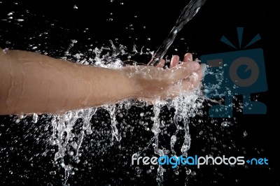 Hand And Pouring Water Splashing On Black Background Stock Photo