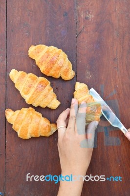 Hand Cutting Croissant Stock Photo