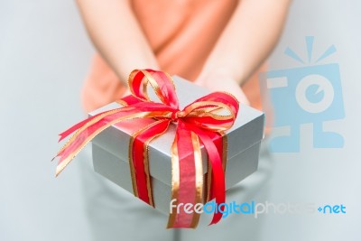 Hand Give Silver Gift Box With Red Ribbon Stock Photo