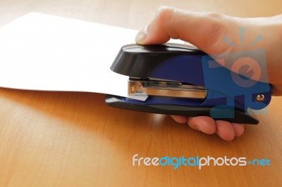 Hand Holding Blue Stapler Stapling Papers, Closeup View Stock Photo