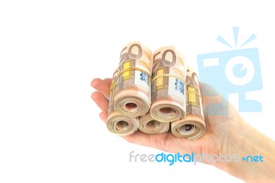 Hand Holding Coiled Euro Notes On White Background Stock Photo