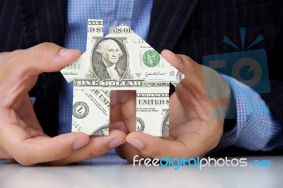 Hand holding dollar house Stock Photo