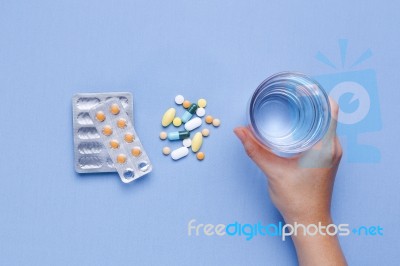 Hand Holding Glass Of Water With Pills Stock Photo