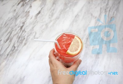 Hand Holding Iced Soft Drink On White Marble Texture Table Backg… Stock Photo