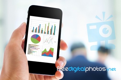 Hand Holding Mobile Phone With Analyzing Graph Stock Photo