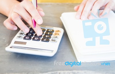 Hand Holding Pen And Pressing Calculator Buttons Stock Photo