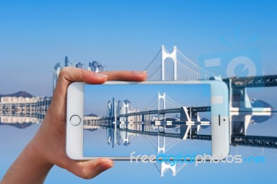 Hand Holding Smart Phone Take A Photo At Gwangan Bridge And Haeundae In Busan,korea Stock Photo