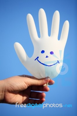 Hand Holding Smiling Glove With Blue Sky Stock Photo