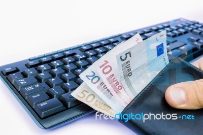 Hand Holding Wallet With Money At Keyboard Stock Photo