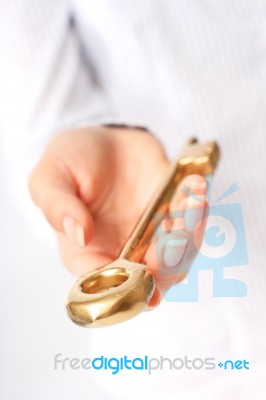 Hand Is Giving A Gold Key Stock Photo