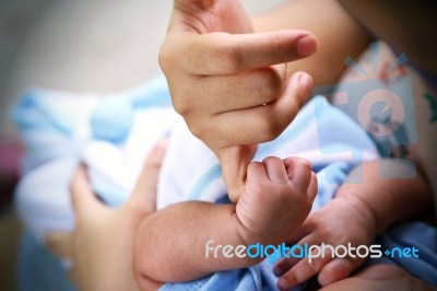 Hand Of A Baby Holding Mother's Finger Stock Photo