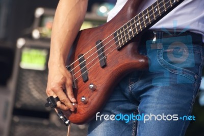 Hand Of Bass Guitarist In Concert Stock Photo