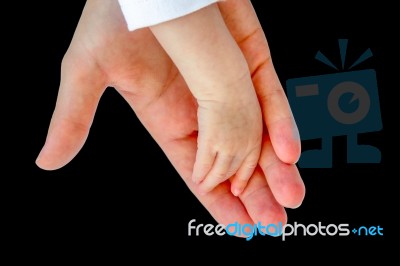 Hand Of Mother With Arm Of Baby On Black Stock Photo