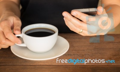 Hand On Coffee Cup And Smartphone Stock Photo