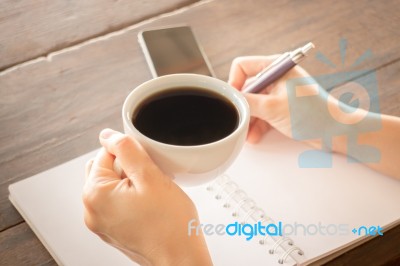 Hand On Coffee Cup And Writing Stock Photo