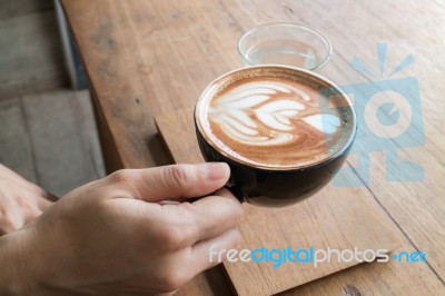 Hand On Hot Coffee Latte Stock Photo