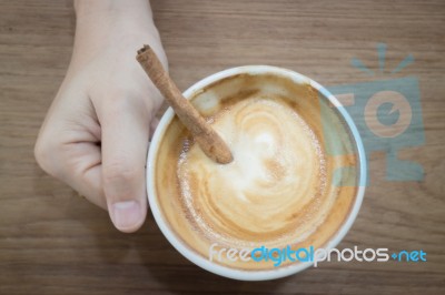 Hand On Hot Cup Of Coffee Latte Stock Photo