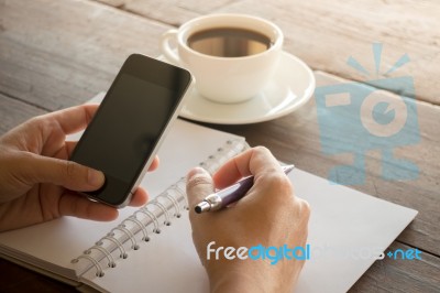 Hand On Smartphone At Coffee Shop Stock Photo