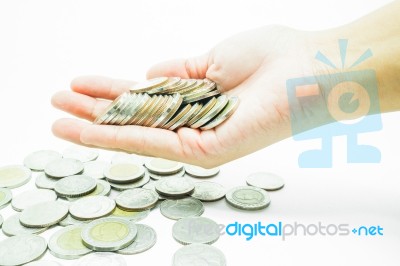 Hand On Thai Baht Coins On White Table Background Stock Photo