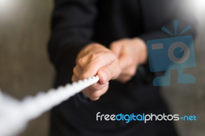 Hand Pulling The Rope, Grey Background, Cooperation Concept As A… Stock Photo