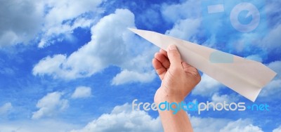 Hand Throwing Paper Plane To Blue Sky Stock Photo